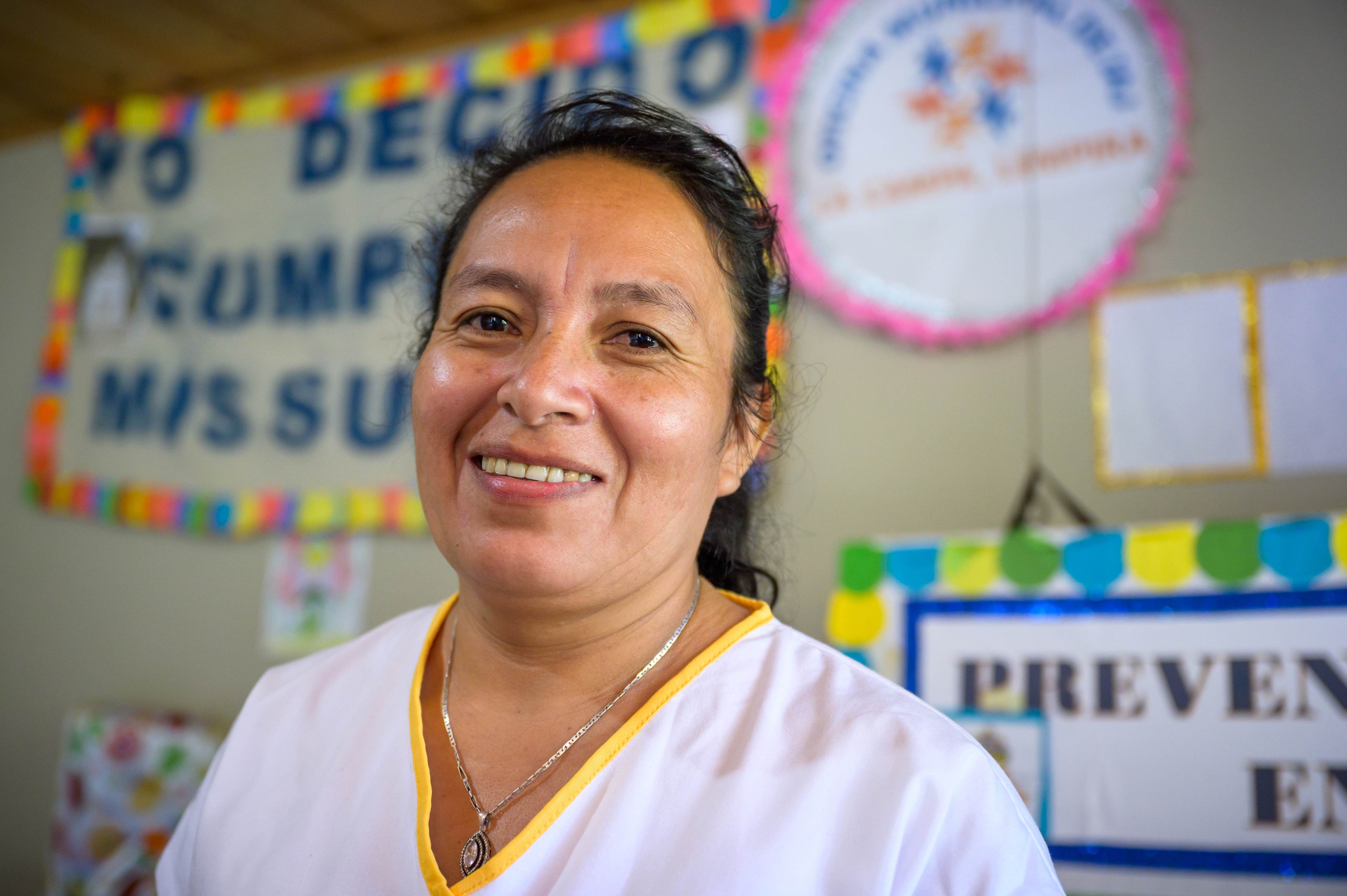 Primer plano de una mujer de Honduras en una escuela sonriendo y mirando a la cámara