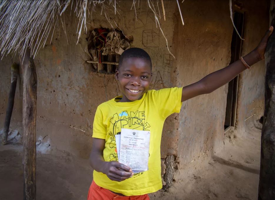 Niño en Mozambique enseña su certificado de nacimiento