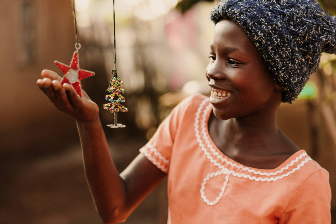 Una niña en Malawi cuelga adornos hechos a mano mientras decora para Navidad.