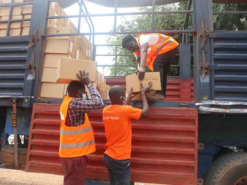 El personal de World Vision Dada Emmanuel Silvano cargando Regalos en Especie para luchar contra la desnutrición en Sudán del Sur