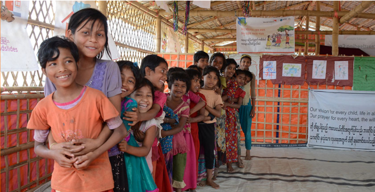Niños y niñas sonriendo en fila india