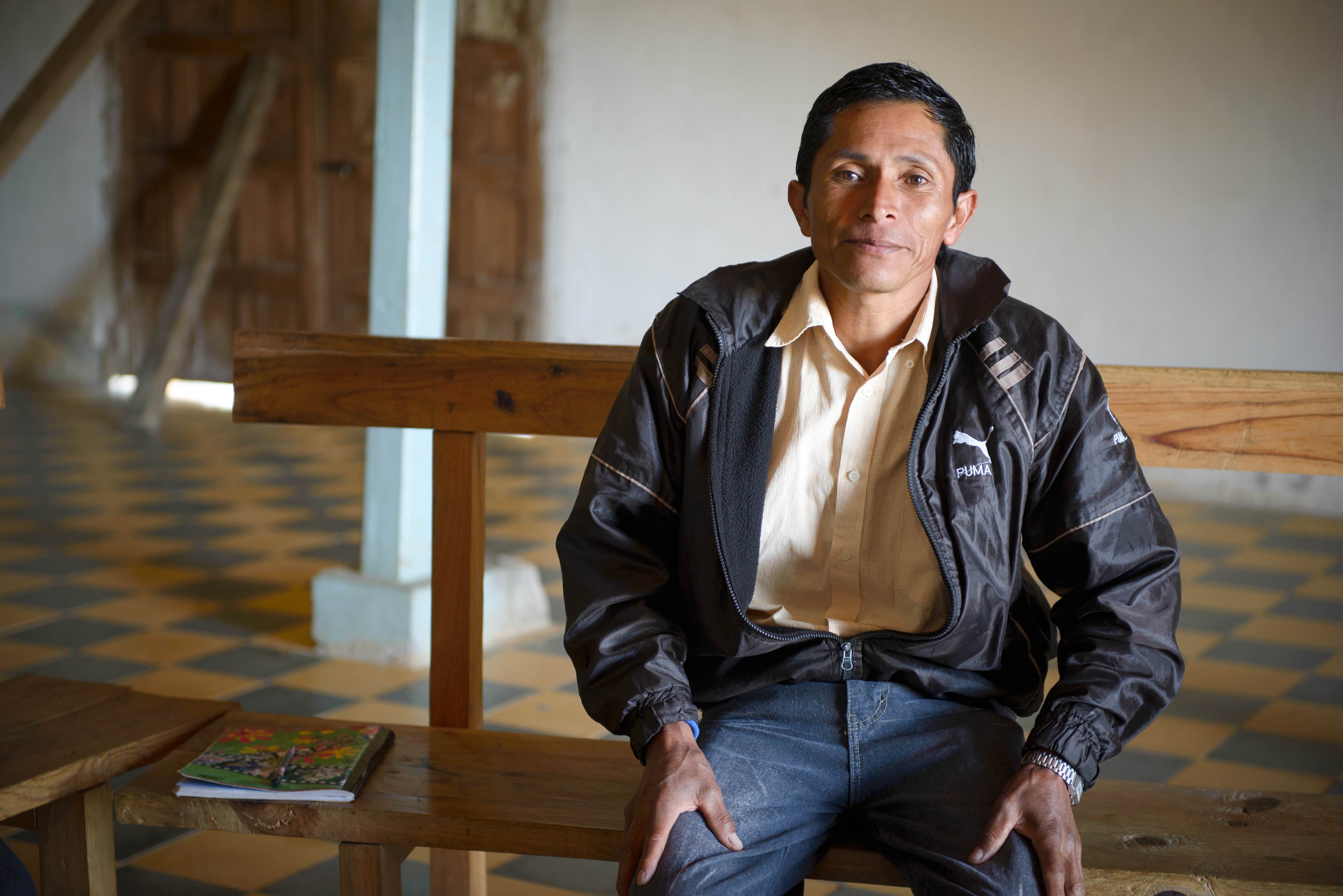 Padre de Honduras que lleva una chaqueta negra mientras mira a lo lejos.