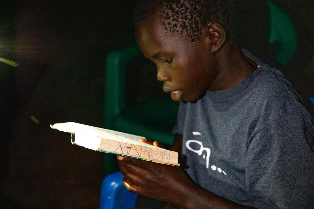 Brian, 13 años, de Uganda, leyendo la Biblia