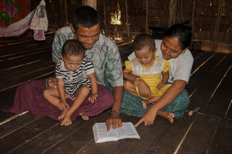 Phaw, de 26 años y Saw Lin, de 27, pasan tiempo leyendo la Biblia con las gemelas Celia Lin y Rolia Lin, ambas de 2 años y 10 meses, en Birmania. (©2018 Visión Mundial /foto de Kyaw Thet Tun)