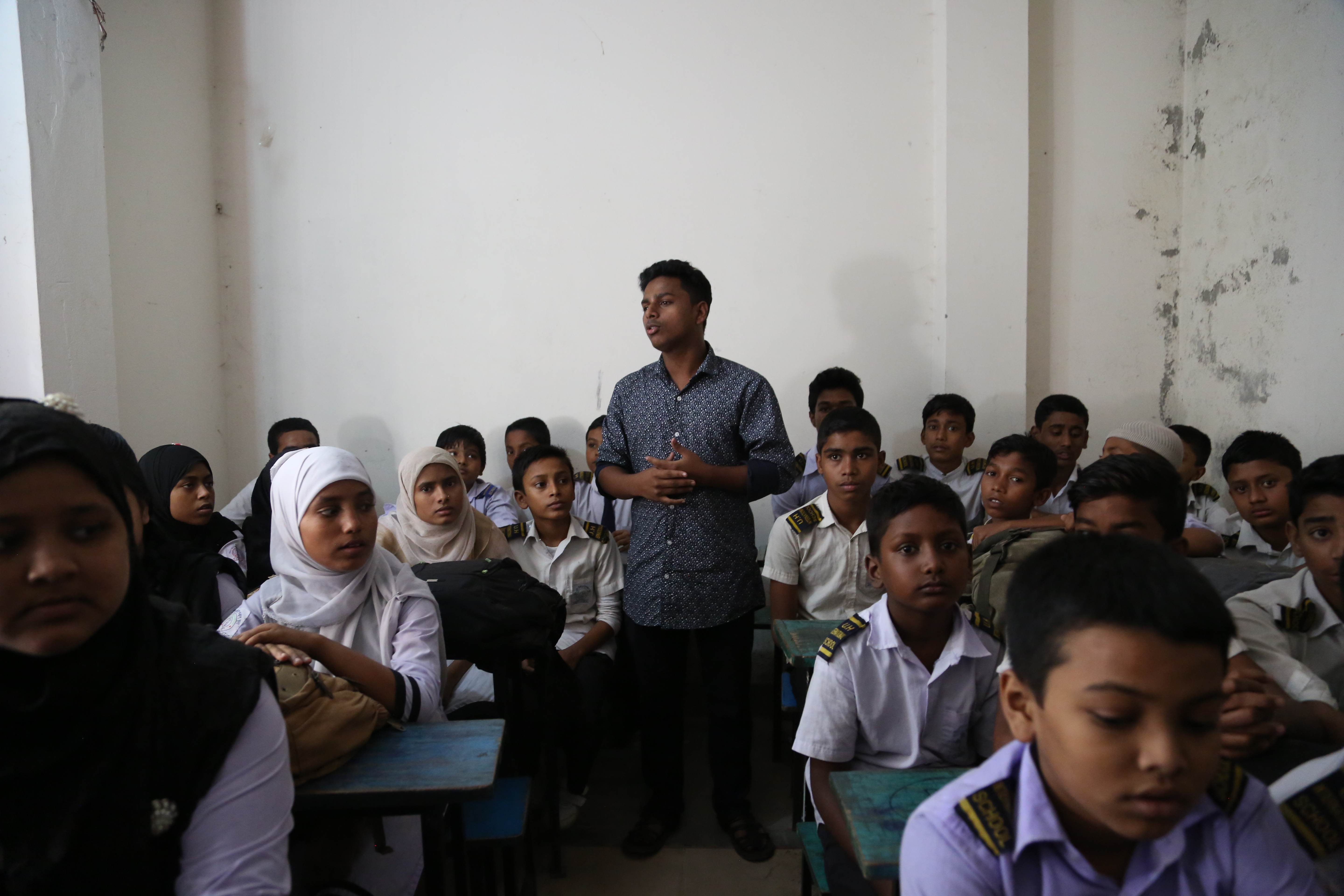 Joven de Bangladesh hablando a un aula llena de niños