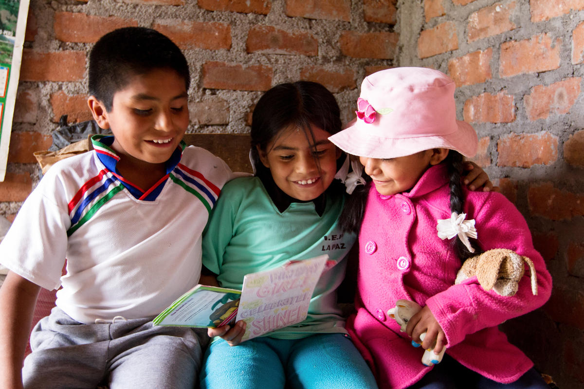 Pedro, un niño apadrinado de Perú, y sus hermanas disfrutan leyendo la carta de su padrino