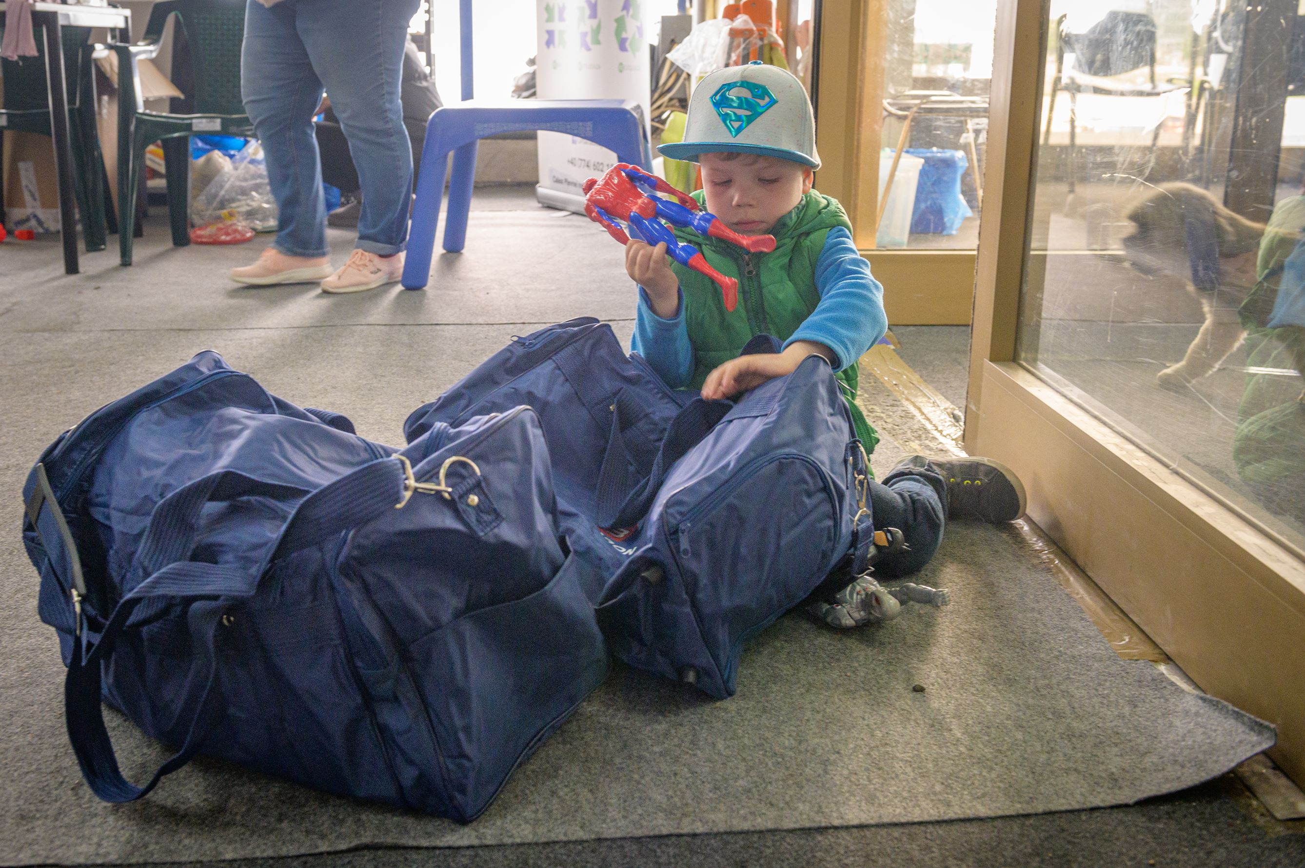Un niño ucraniano guarda los juguetes donados en una bolsa de viaje en Rumanía
