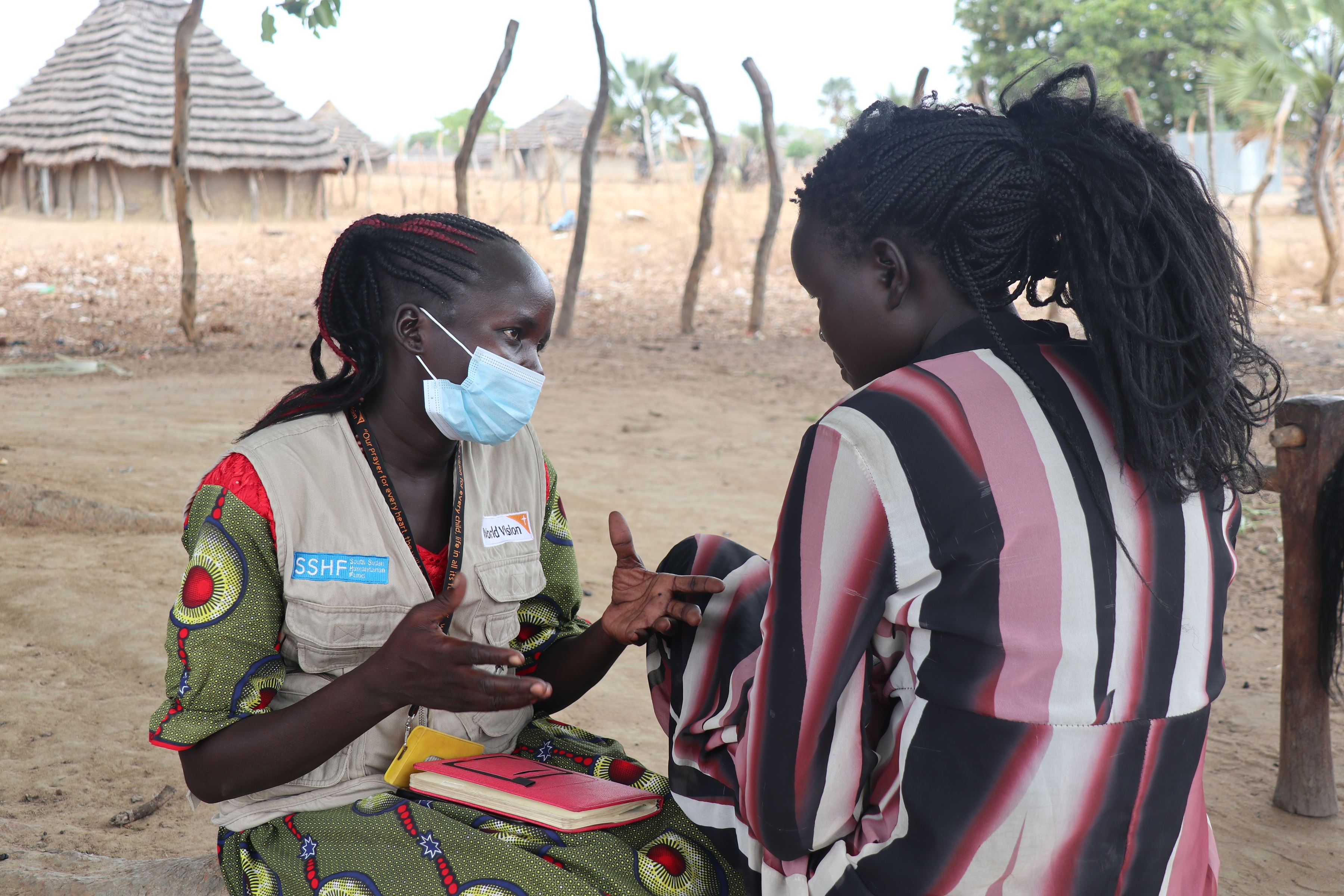 La trabajadora social de World Vision, Pasquina Diu, interactúa con la niña sudanesa Katina en una de sus visitas.