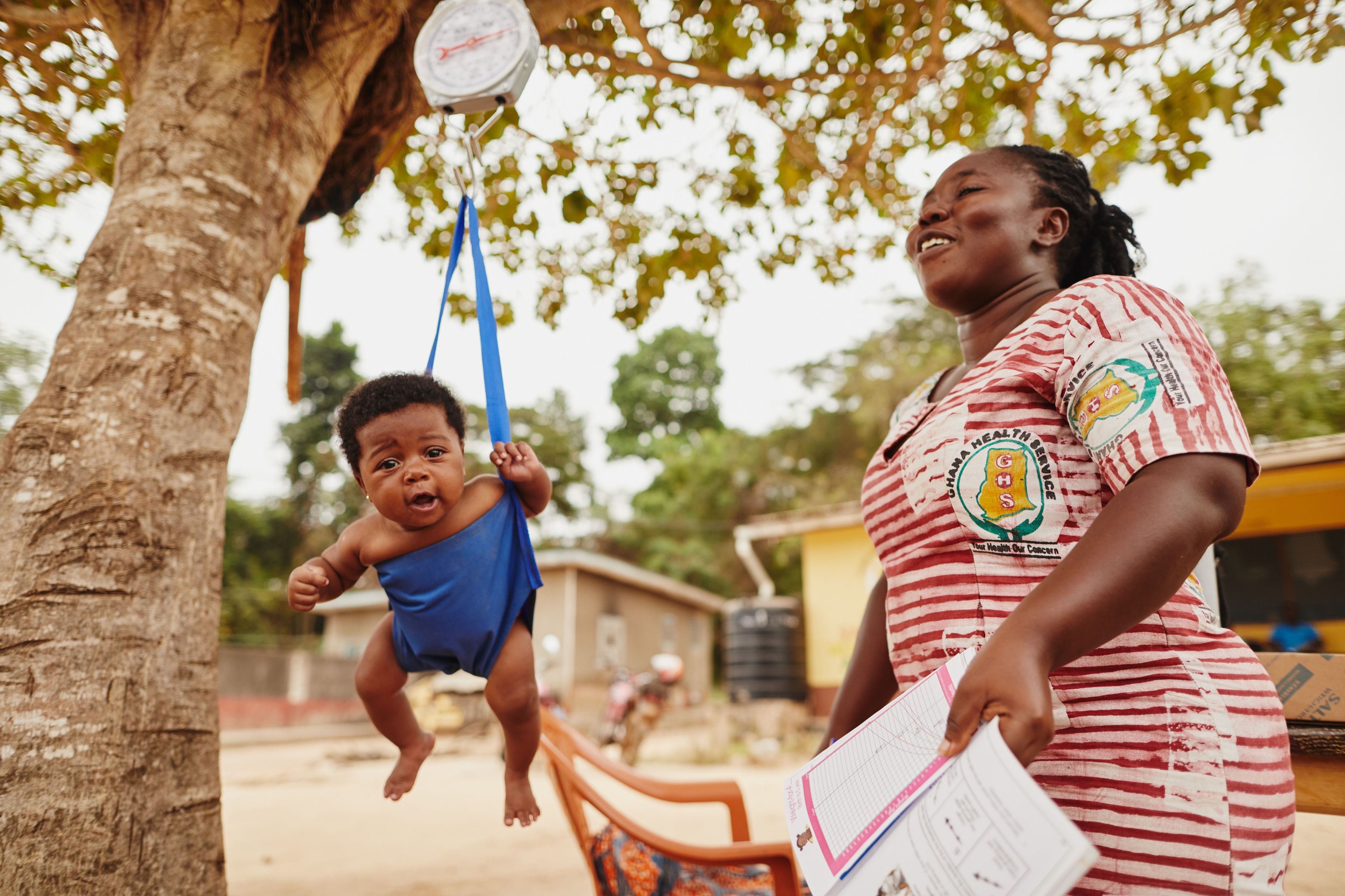 Madre de Ghana y su bebé que está en un columpio