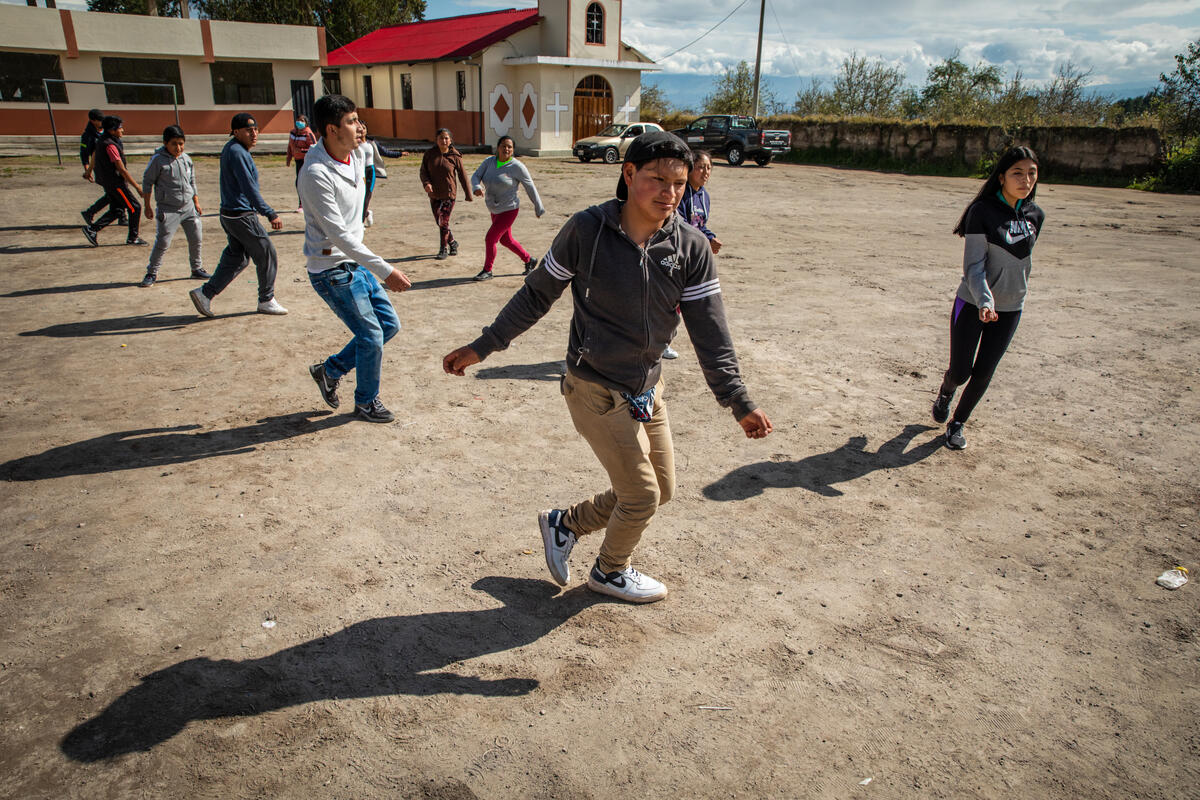 Daniel, de 17 años, de Ecuador, dirige a los miembros del grupo de baile de la comunidad mientras ensayan para un próximo desfile.